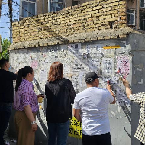 山化社区联合“双报道”单位开展清理墙面小广告活动