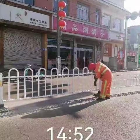 环卫工人擦洗护栏     扮靓街道迎新春