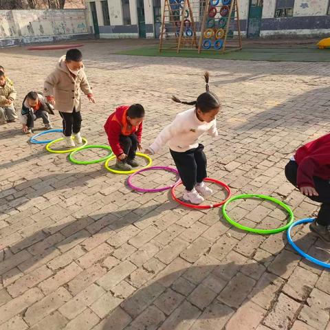 西方屯幼儿园，体育活动《青蛙跳》模仿青蛙的动作，学习双脚并拢向前跳，训练幼儿肌肉的耐力。