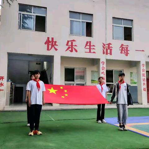 香港浸会大学大学生与拍石头乡中心小学学生共同参加升旗仪式