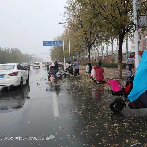 《育才学校门口的温暖守护：雨中的爱之画卷》