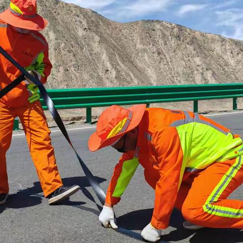 “精准粘贴贴缝带，守护平安出行路”——冷湖公路段进行路面裂缝处治工作