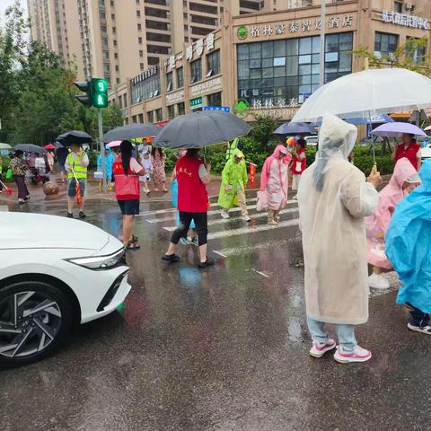 雨落护学路，志愿暖童心——这抹“志愿红”，是雨天里最安心的守护
