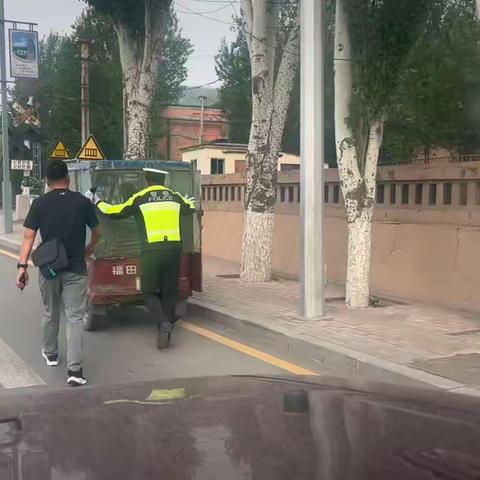 三轮车突发故障路中停，溪湖交警徒手推车献真情