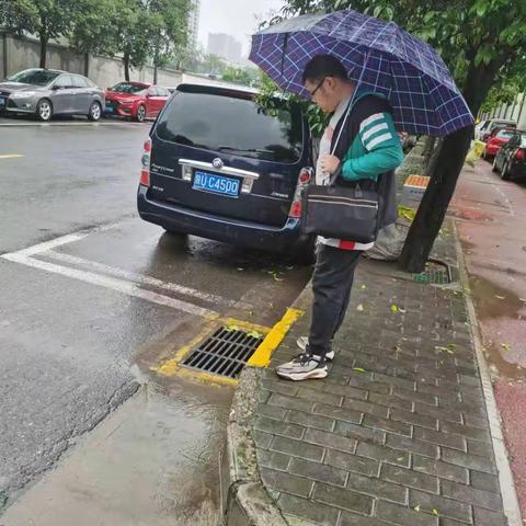 筑牢安全堤坝    网格员行走在雨中