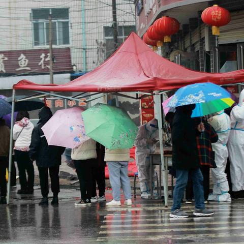 爱心协会志愿者在风雨中协助全民核酸检测